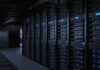 Rows of server racks illuminated in a dark data center
