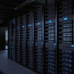 Rows of server racks illuminated in a dark data center