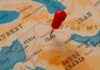 A map of the Middle East with a red pin marking Iraq