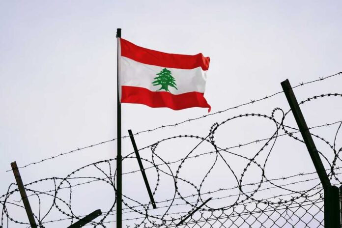 Lebanese flag waving next to barbed wire fence