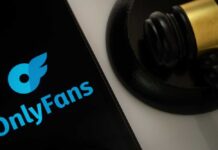 OnlyFans logo displayed on a smartphone next to a gavel