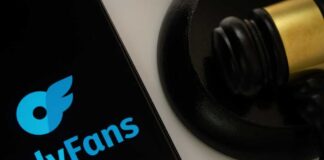 OnlyFans logo displayed on a smartphone next to a gavel