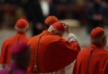 Cardinals in red robes participating in a religious ceremony