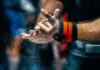 Athlete preparing for weightlifting by chalking hands