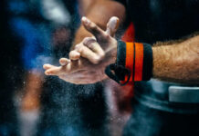 Athlete preparing for weightlifting by chalking hands