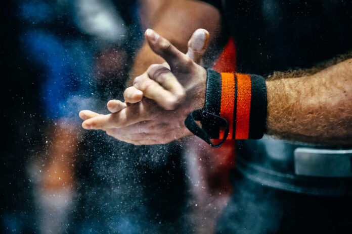 Athlete preparing for weightlifting by chalking hands