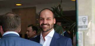Man in blue suit smiling in a group setting