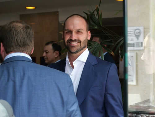 Man in blue suit smiling in a group setting