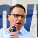 Shapiro Firestorm Returns—Facts Don’t Blink Man with glasses speaking into a microphone