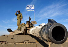 Vance Claps Back—Israel Sidelined? Soldier saluting from atop a tank with an Israeli flag in the background