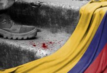 Cartel Grip Tested in Colombia Runoff A military boot on concrete steps with blood stains and a Colombian flag draped nearby