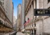 View of Wall Street with skyscrapers and American flags