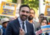 Ticket Gimmick Ignites NYC Backlash A man speaking at a rally with supporters holding protest signs