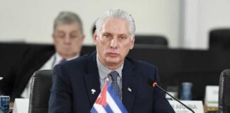 Cuban representative at a political meeting with a flag on the table