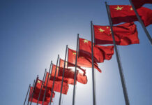 Shock Doctrine: Speed Beats Armor In China’s Plan Multiple Chinese flags waving against a clear blue sky