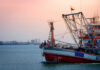 Protected Pacific Reopened — Habitat at Risk Fishing boat on the water during sunset with an industrial area in the background