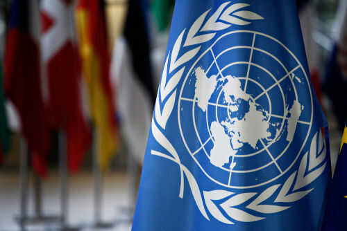United Nations flag with other flags in background