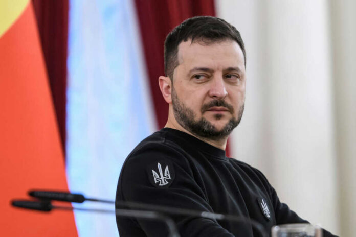 man in black sweatshirt at a podium looking to the side