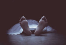 Feet protruding from under a white sheet.
