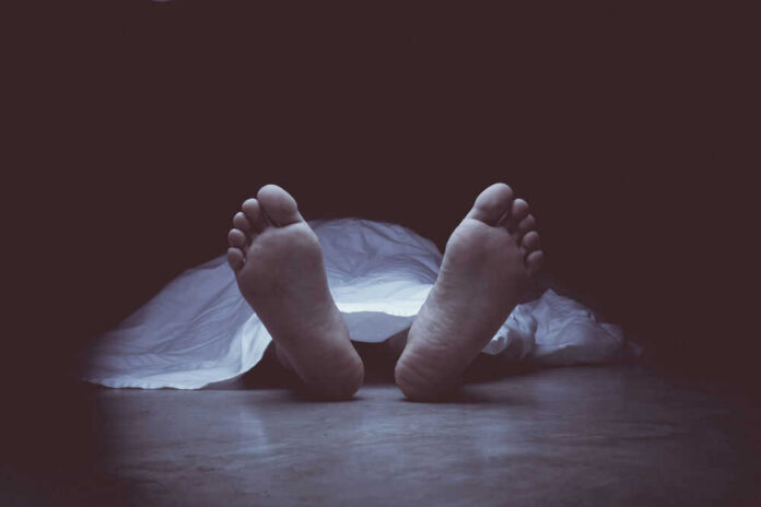 Feet protruding from under a white sheet.
