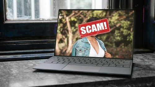 Laptop screen with a scam warning image.