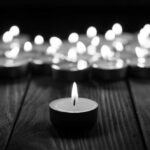 Hypoxia Takes Over—No One Wakes Single candle burning among many on wooden surface.