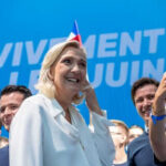 Convicted—But Running: France Erupts Group taking selfie with smiling woman at event
