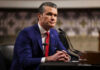 Hegseth Pulls Plug—Why Now? Man in blue suit speaking at a microphone