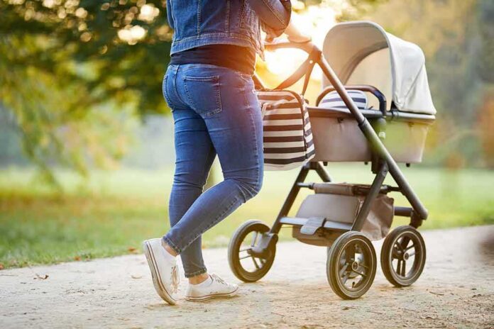 shutterstock_1042556074 Person pushing a baby stroller on a park path