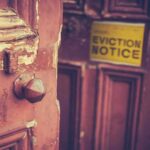 Weathered wooden door with eviction notice