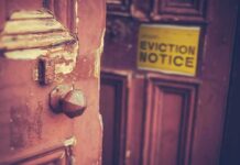 Weathered wooden door with eviction notice