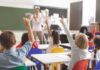 Feds Probe Minnesota Over Transgender Dolls Elementary students raise hands in a classroom