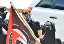 Texas Verdicts Shatter ‘No Antifa Terror’ Claim Masked protesters holding a black and red flag