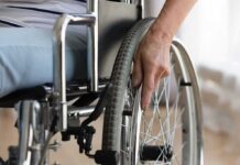 DOJ Memo Sparks Disability Uproar Hand on wheelchair wheel