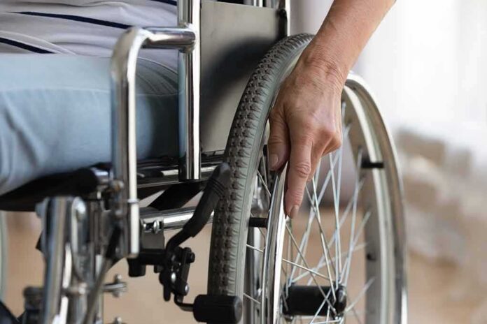 shutterstock_1681615543 Hand on wheelchair wheel