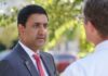 Sanders-Khanna Gambit Risks Revenue Backfire Two professionals engaged in conversation outdoors