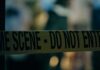 ICE Stop Chaos: Cameras Missing, Questions Explode Caution tape marking a crime scene with blurred figures in the background