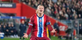 Soccer player holding a ball in a stadium with a cheering crowd