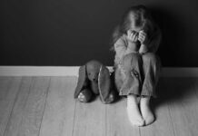 Gang Racket Exposed—Victims As Young As 14 Child sitting on floor with face in hands beside stuffed bunny