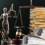 Judge Flinches At Brutal Kirk Video Lady Justice statue beside gavel and stacks of legal files
