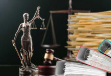 Judge Flinches At Brutal Kirk Video Lady Justice statue beside gavel and stacks of legal files