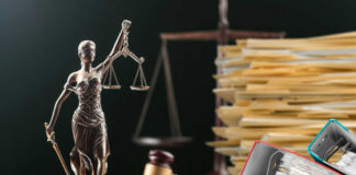 Lady Justice statue beside gavel and stacks of legal files