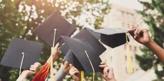 Graduates raise mortarboards with tassels in celebration