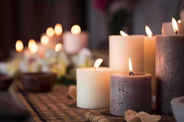 shutterstock_1123160123 lit pillar candles on a woven mat