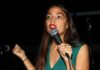 Woman speaking into a microphone on stage