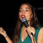 Woman speaking into a microphone on stage