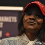woman in a red cap holding a microphone