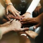 Google Kingpin Jumps—$10B Bet on Robo-Science Group hands stacked in a teamwork gesture