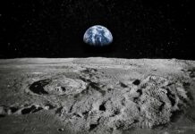 Moon surface with footprints and Earth rising over the horizon
