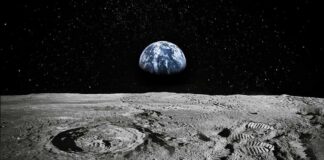 Moon surface with footprints and Earth rising over the horizon